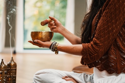 In brown knitting a sweater with a brown ceramic cup of woman
